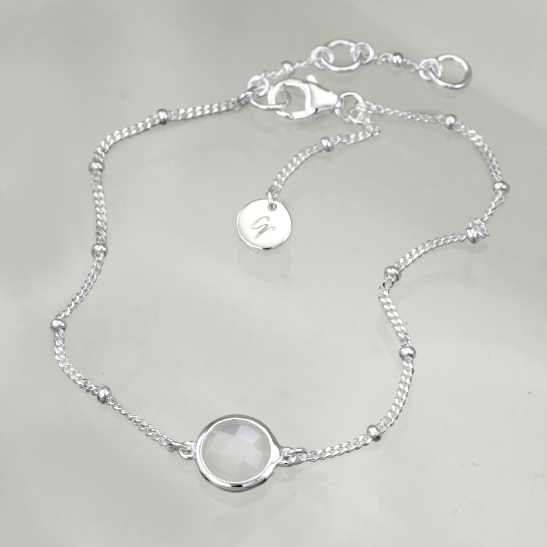 Sterling silver beaded chain bracelet with moonstone on a reflective background