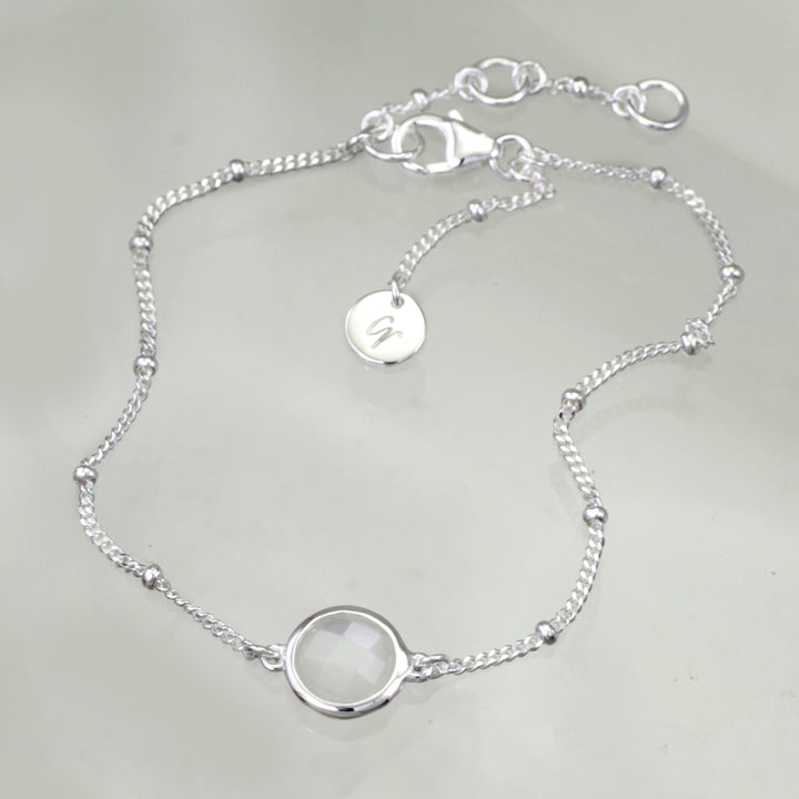 Sterling silver beaded chain bracelet with moonstone on a reflective background