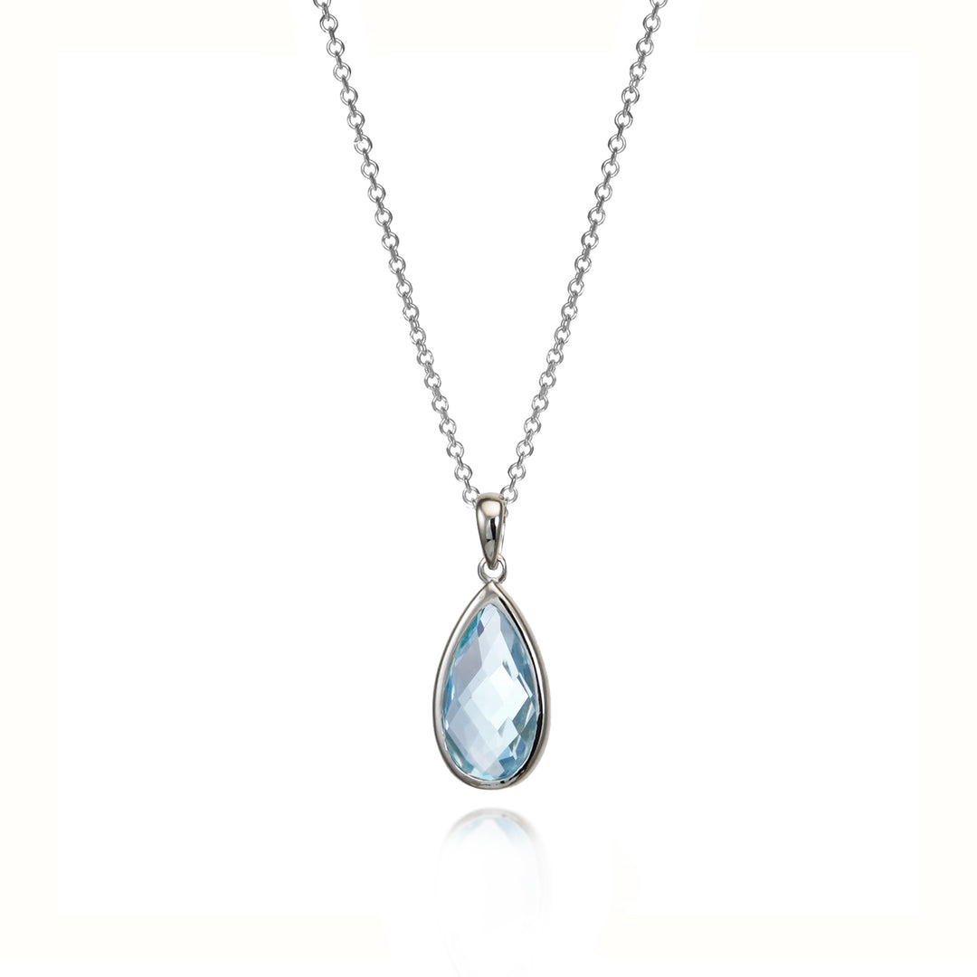 Teardrop-shaped blue topaz gemstone pendant on a silver chain against a white background