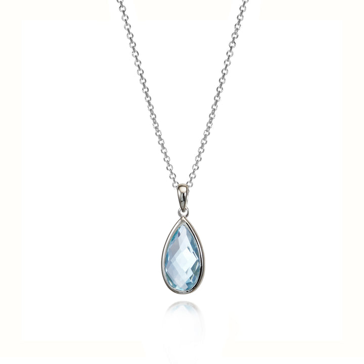 Teardrop-shaped blue topaz gemstone pendant on a silver chain against a white background