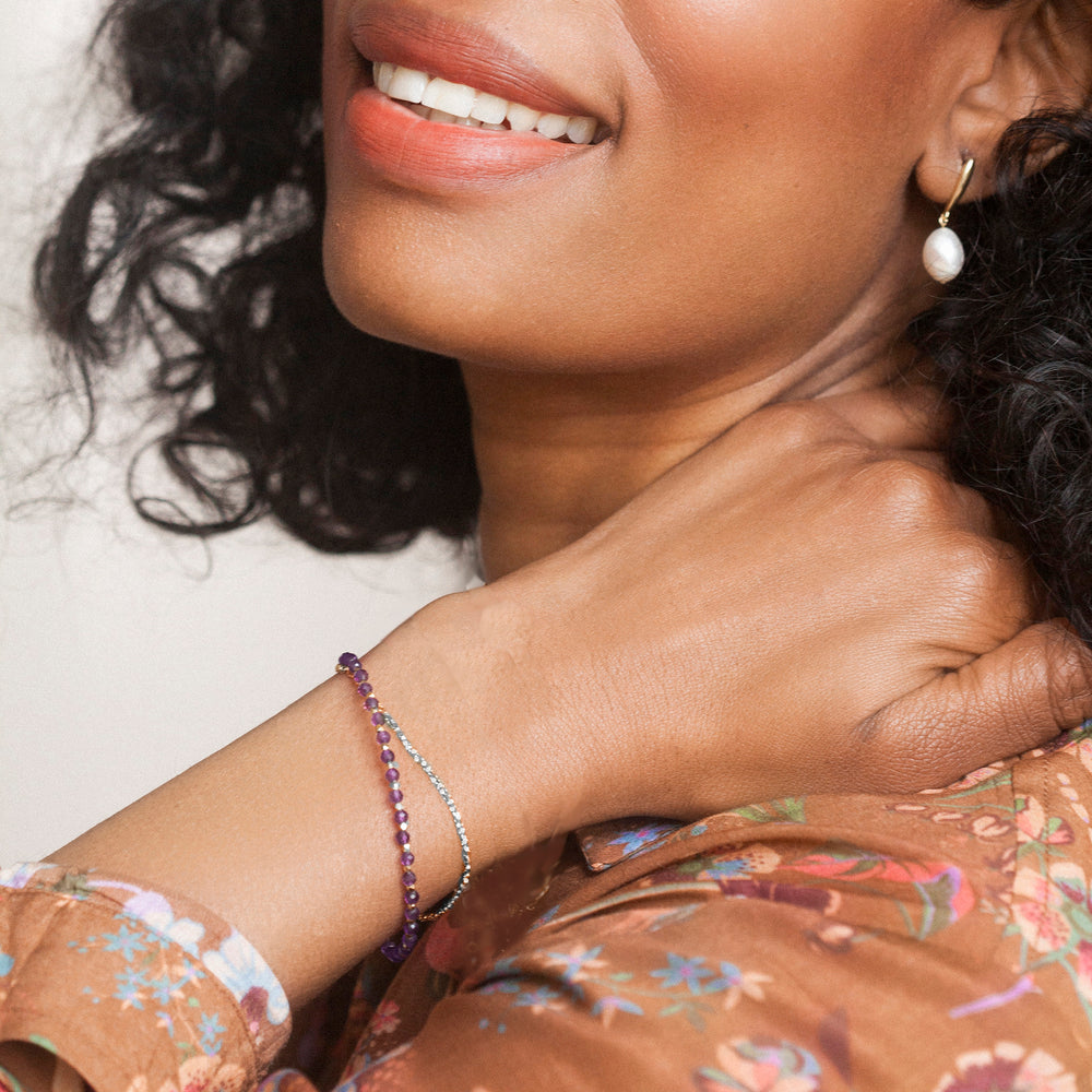 Woman wearing a sterling silver beaded compass bracelet in amethyst
