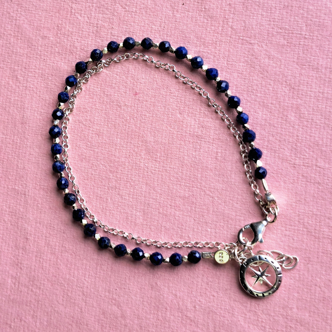 Sterling silver beaded compass bracelet in lapis lazuli on a pink background
