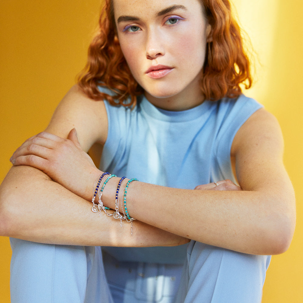 Woman wearing a sterling silver beaded compass bracelet in lapis lazuli