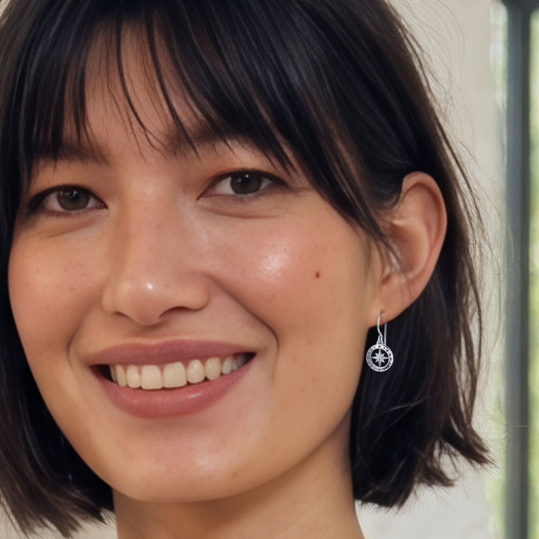 Close-up of woman wearing sterling silver compass drop earrings