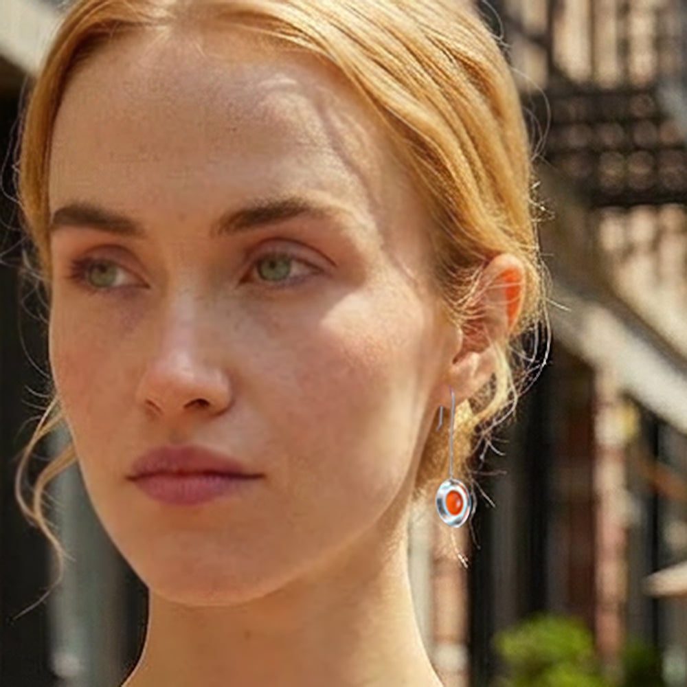 Woman wearing sterling silver long dish drop earrings with oval carnelian cabochon gemstones