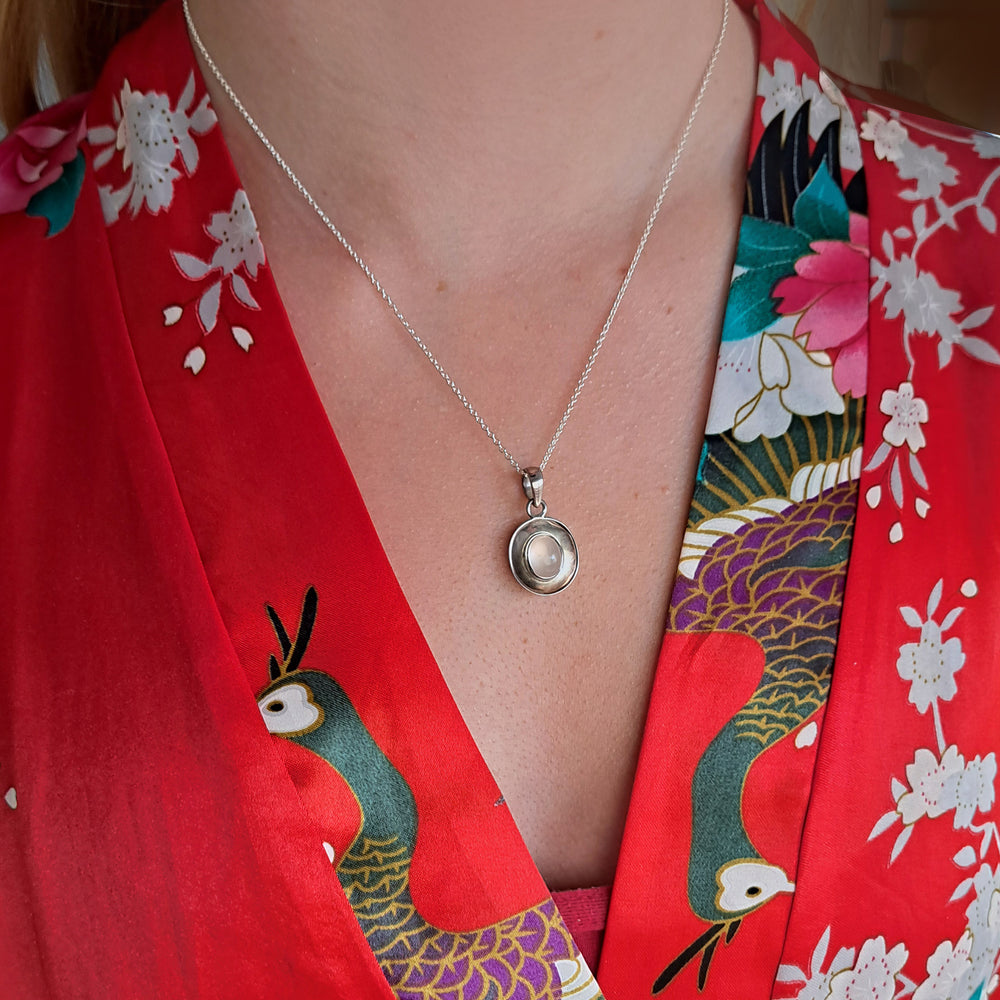Model wearing a sterling Silver Dish Shaped Pendant with a rose quartz cabochon gemstone