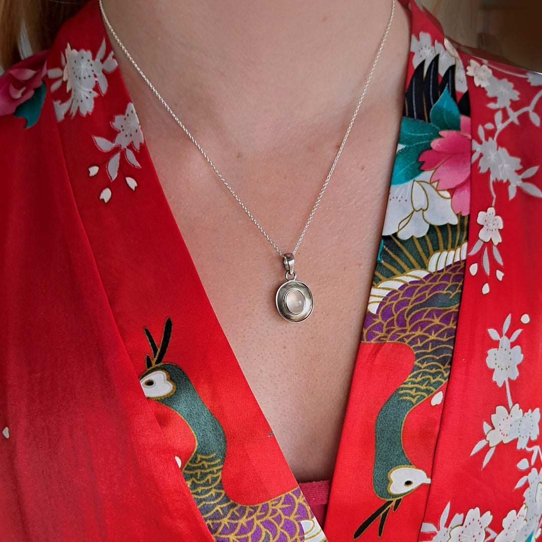 Model wearing a sterling Silver Dish Shaped Pendant with a rose quartz cabochon gemstone