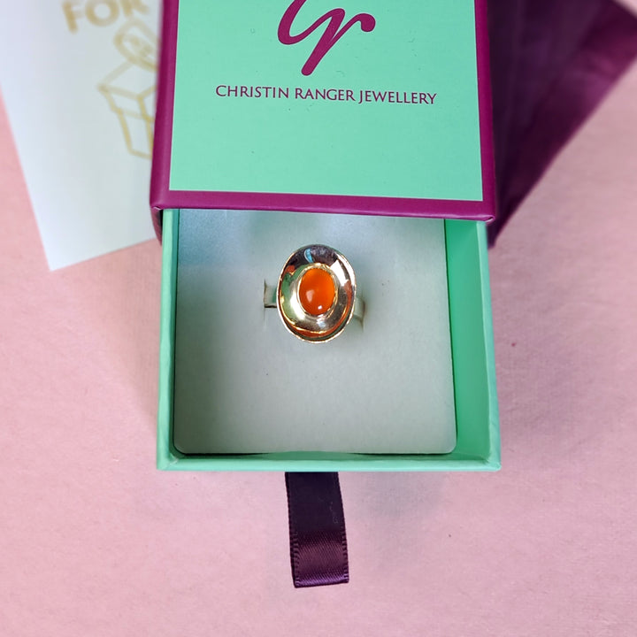 Sterling silver dish shaped ring set with a carnelian cabochon gemstone in Christin Ranger Jewellery gift packaging