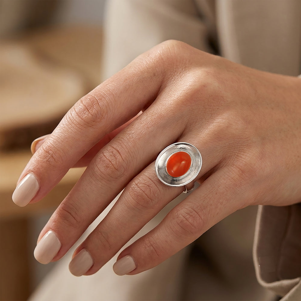 Woman wearing a sterling silver dish shaped ring set with a carnelian cabochon gemstone