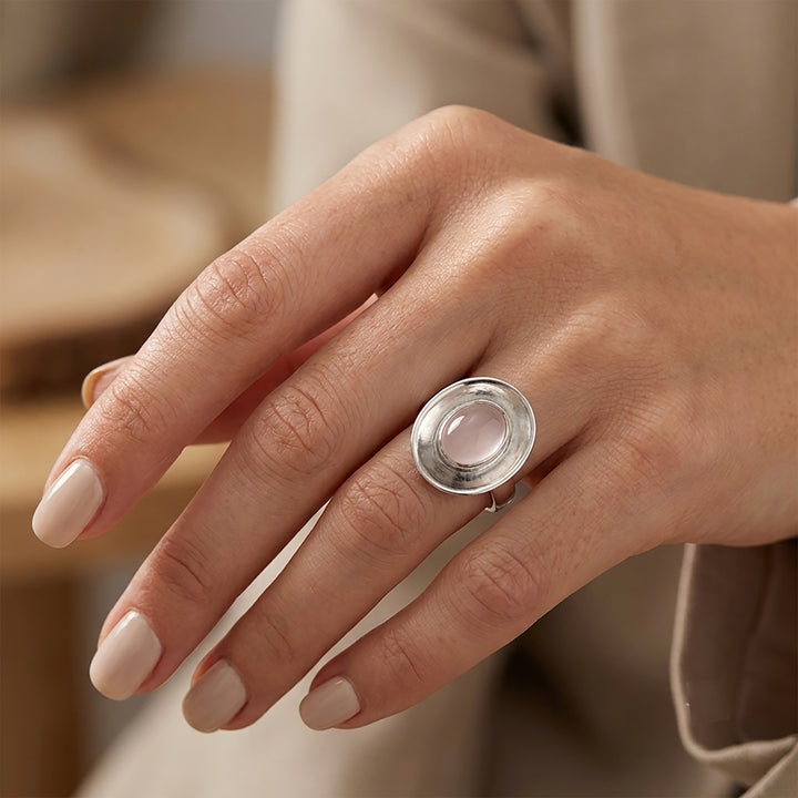 Woman wearing a sterling silver dish shaped ring with rose quartz cabochon gemstone