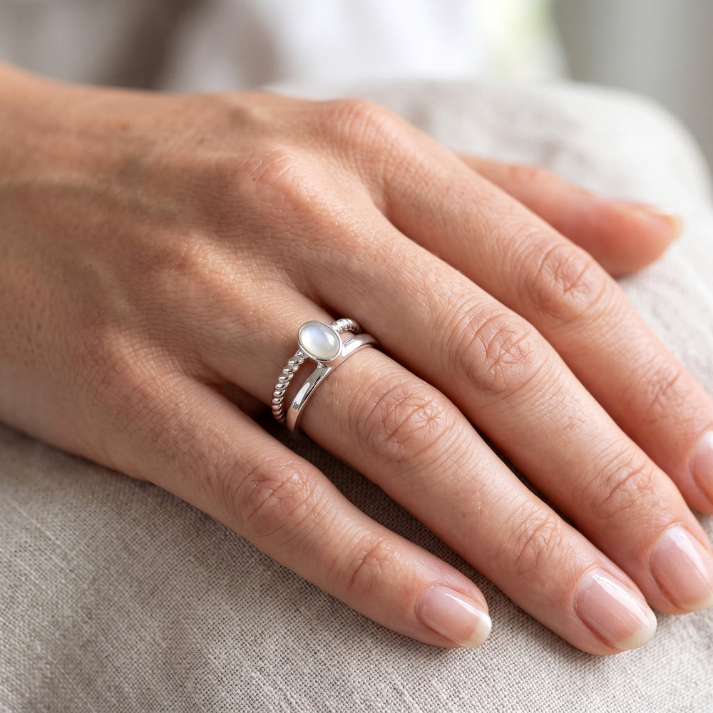 Close-up of a sterling silver double band ring with moonstone on a woman's hand