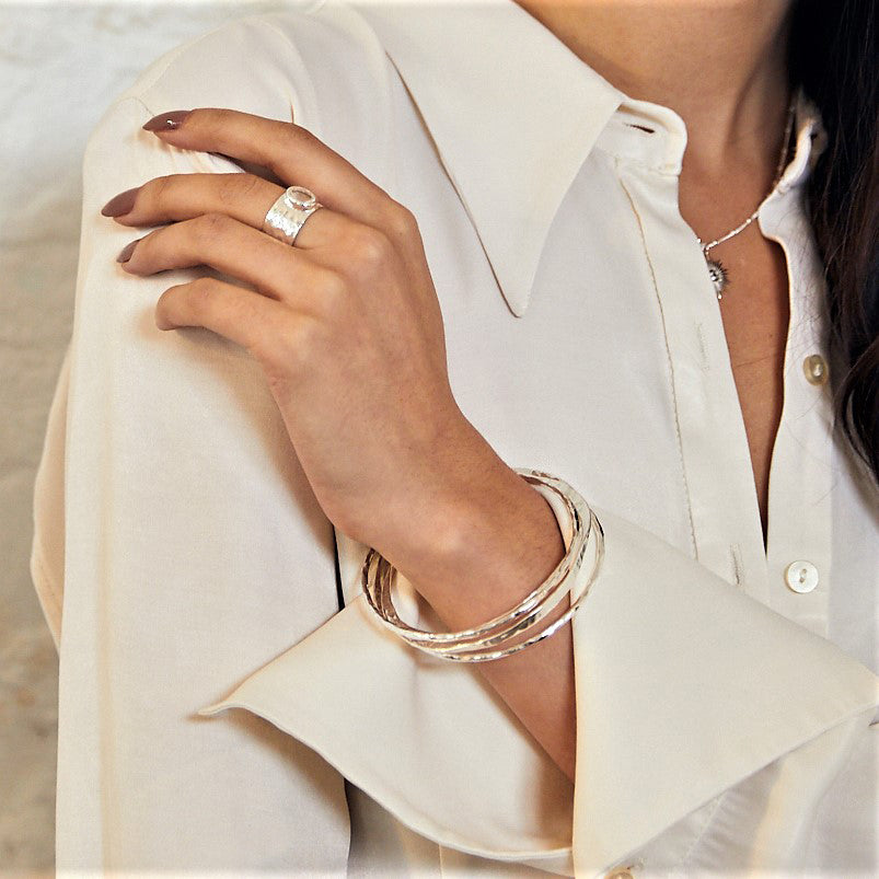 woman wearing sterling silver double take bangles with hammered texture