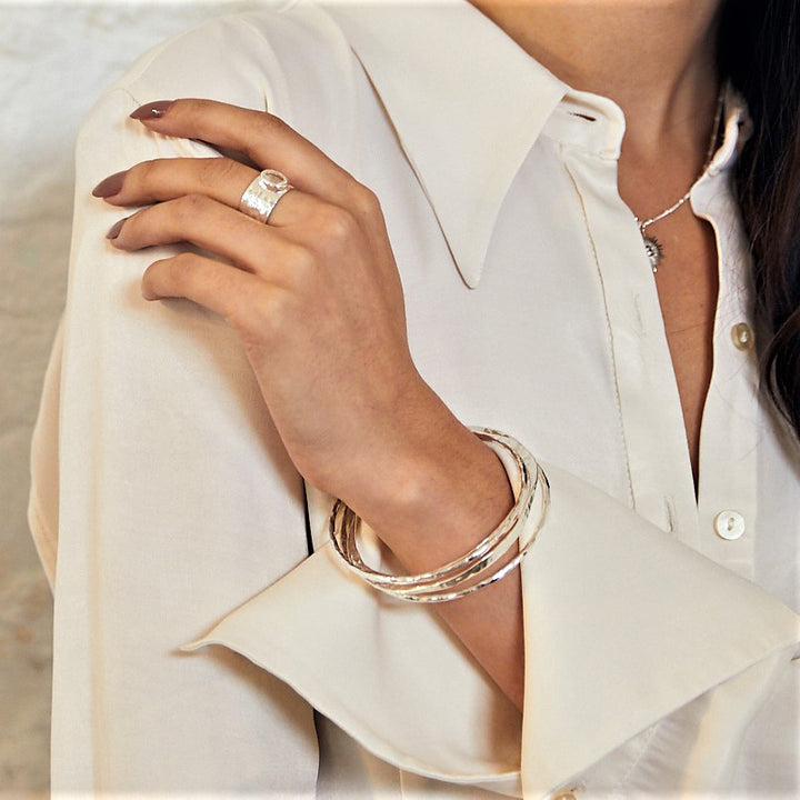 woman wearing sterling silver double take bangles with hammered texture