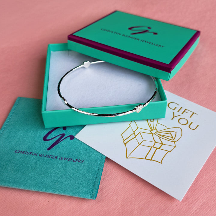 Sterling silver four heart hammered bangle in a Christin Ranger Jewellery gift box with pouch and card