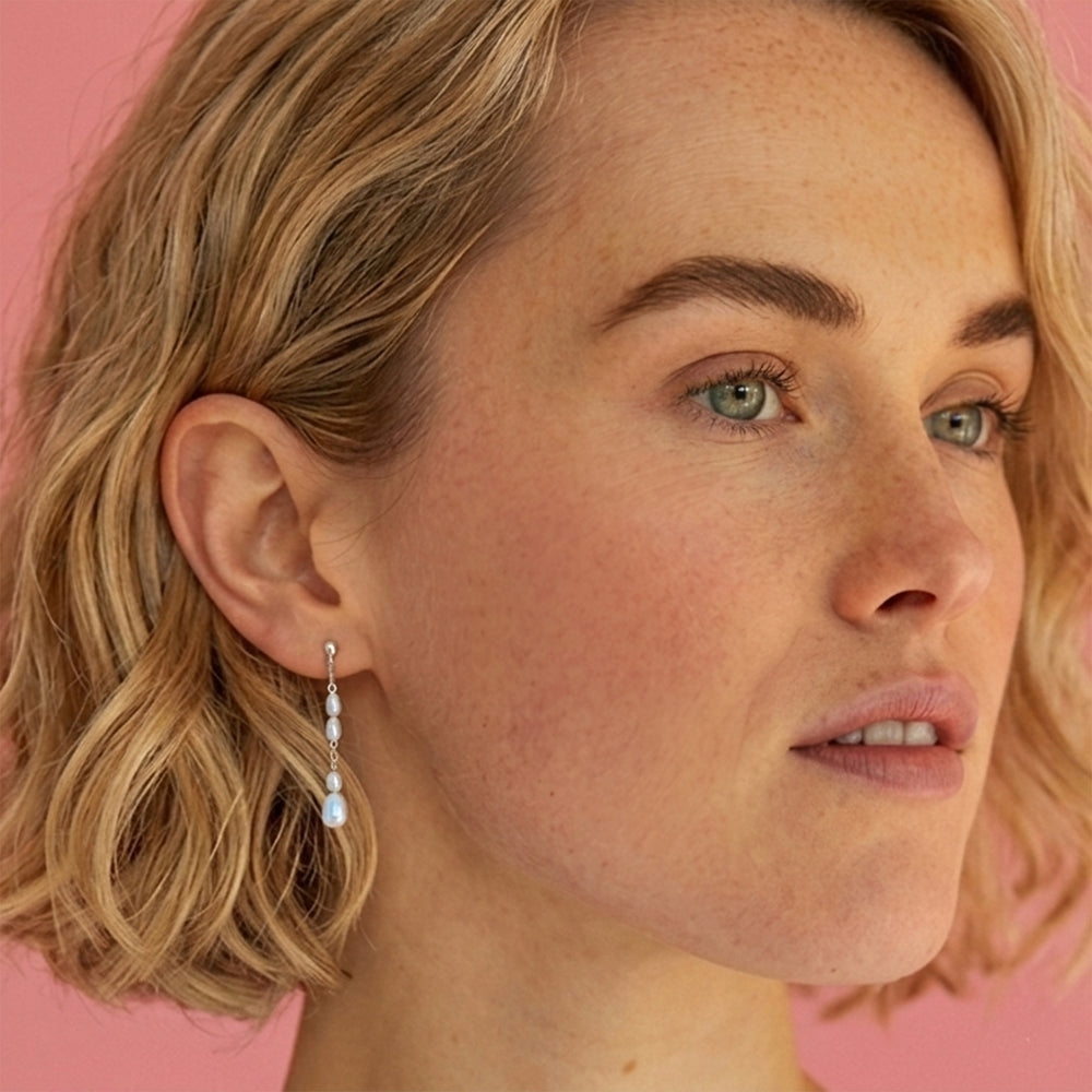 Woman wearing sterling silver freshwater pearl drop stud earrings