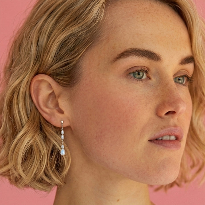 Woman wearing sterling silver freshwater pearl drop stud earrings