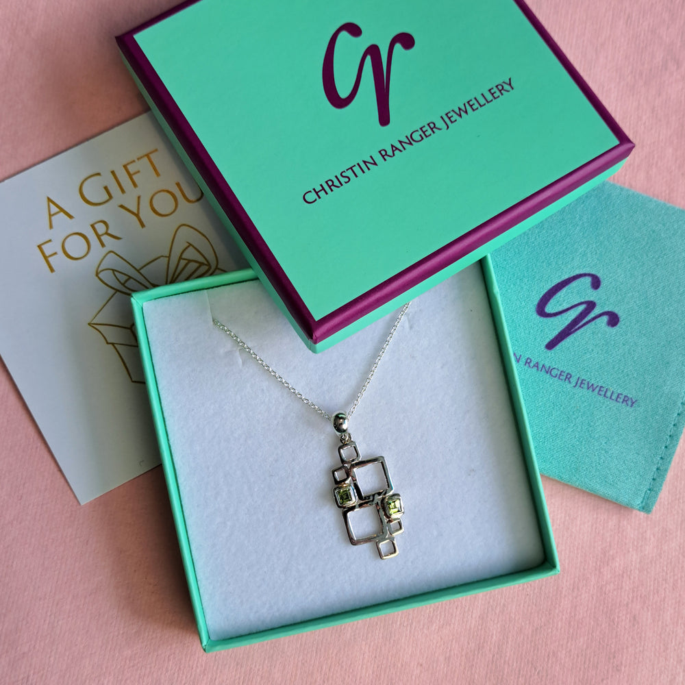 Sterling silver geometric pendant necklace with peridot cabochons in Christin Ranger Jewellery gift packaging