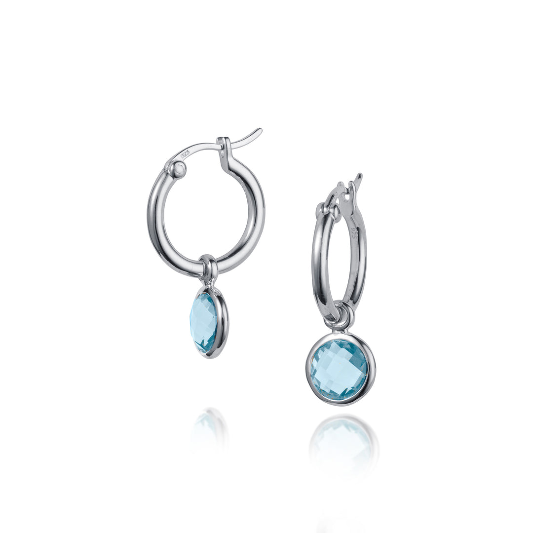 Silver hoop earrings with blue gemstones on a white background