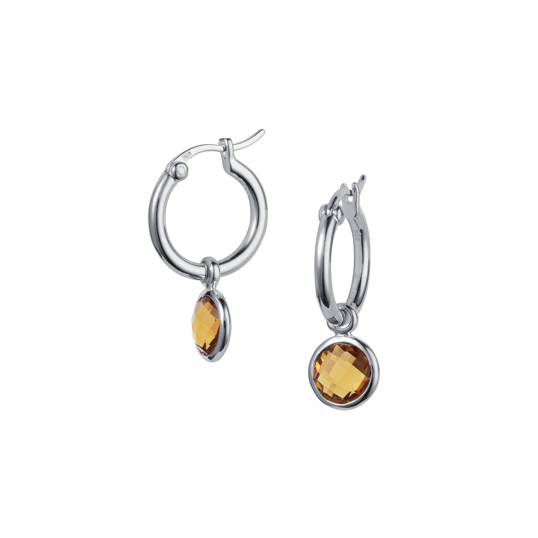 Silver hoop earrings with brown gemstones on a white background