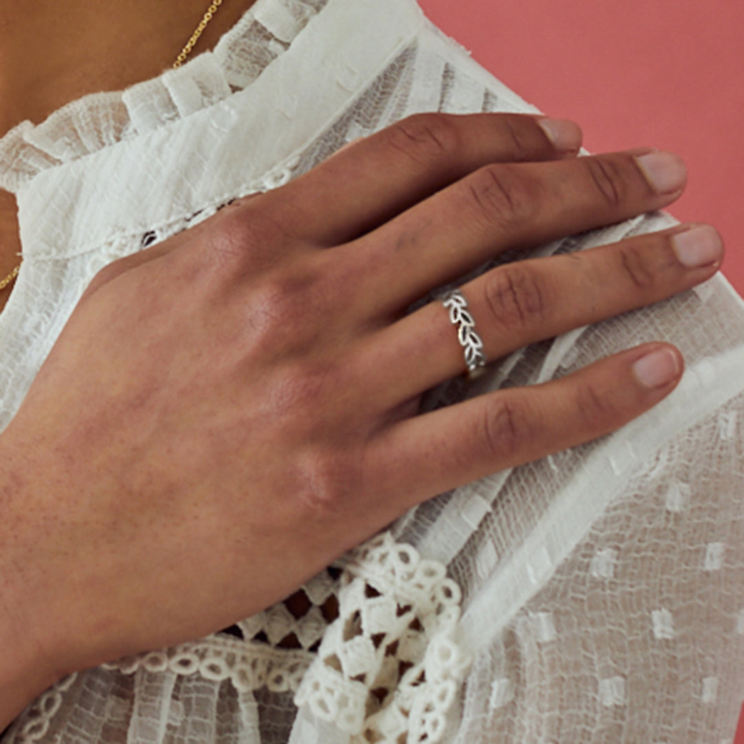 Model wearing a silver garland ring with pink background