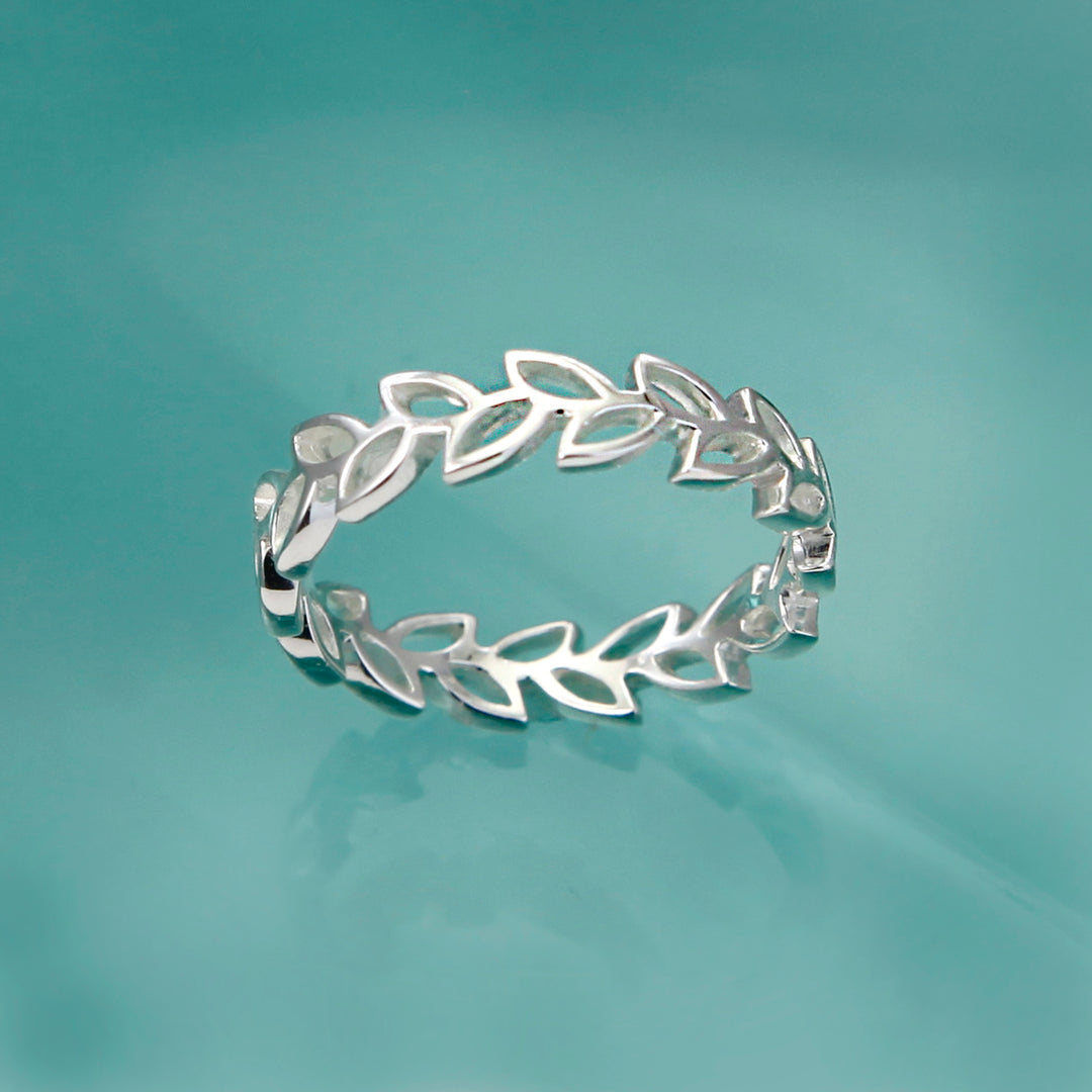Silver garland design ring on aqua background
