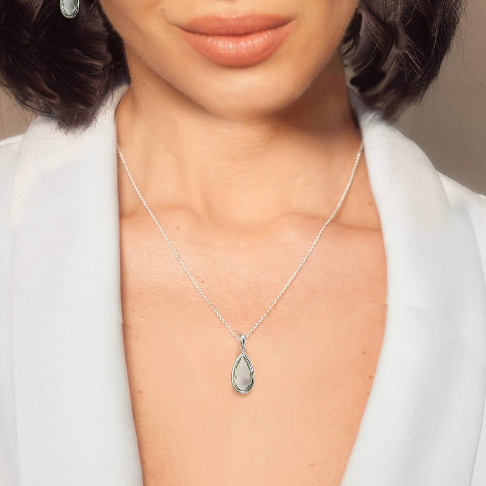 Woman wearing sterling silver pear drop pendant necklace in green amethyst