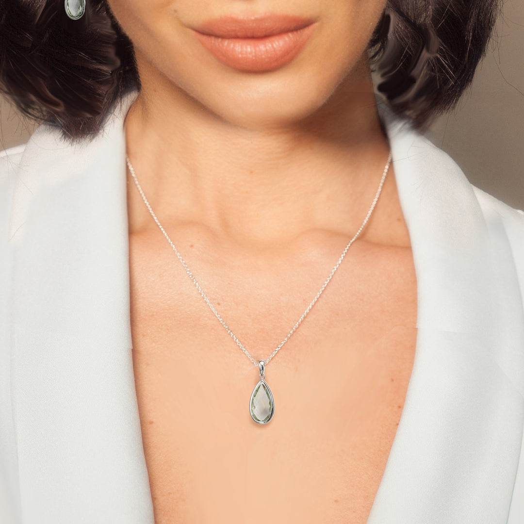 Woman wearing sterling silver pear drop pendant necklace in green amethyst