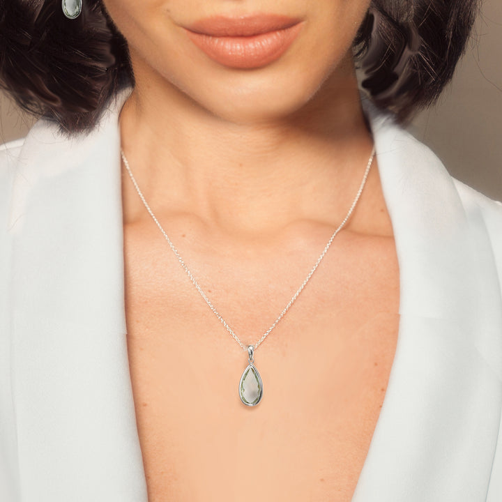 Woman wearing sterling silver pear drop pendant necklace in green amethyst