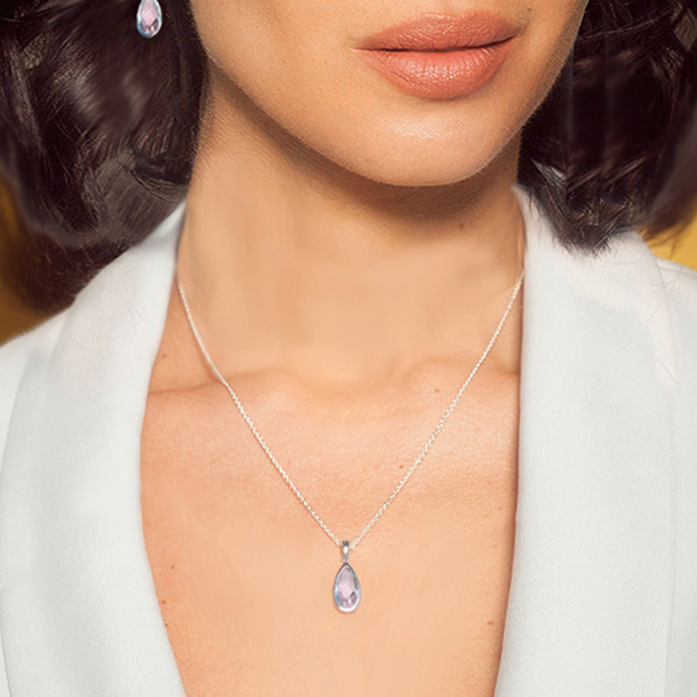 CLose-up of woman wearing a sterling silver pear drop pendant necklace with rose quartz