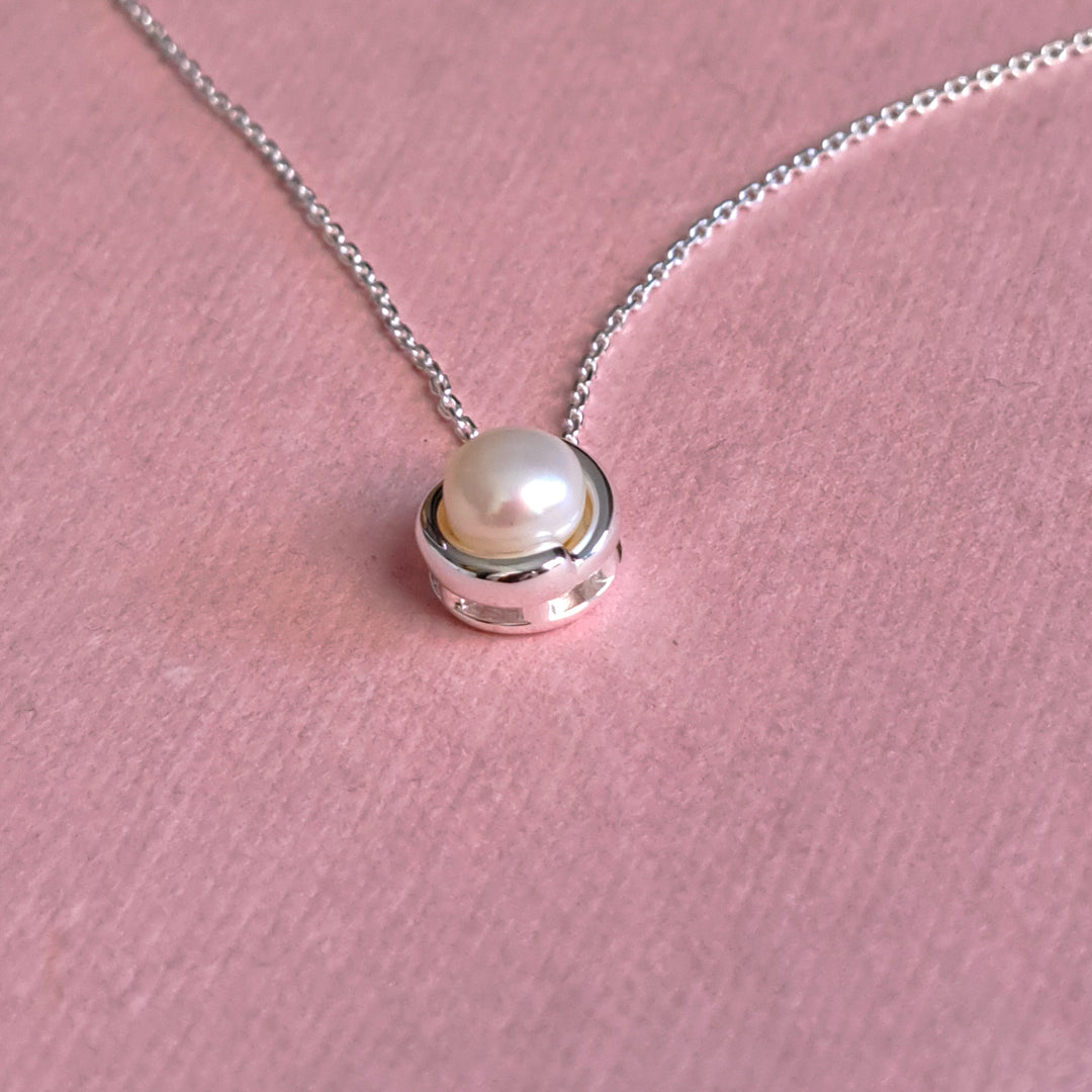 Close-up side view of sterling silver pearl pendant necklace