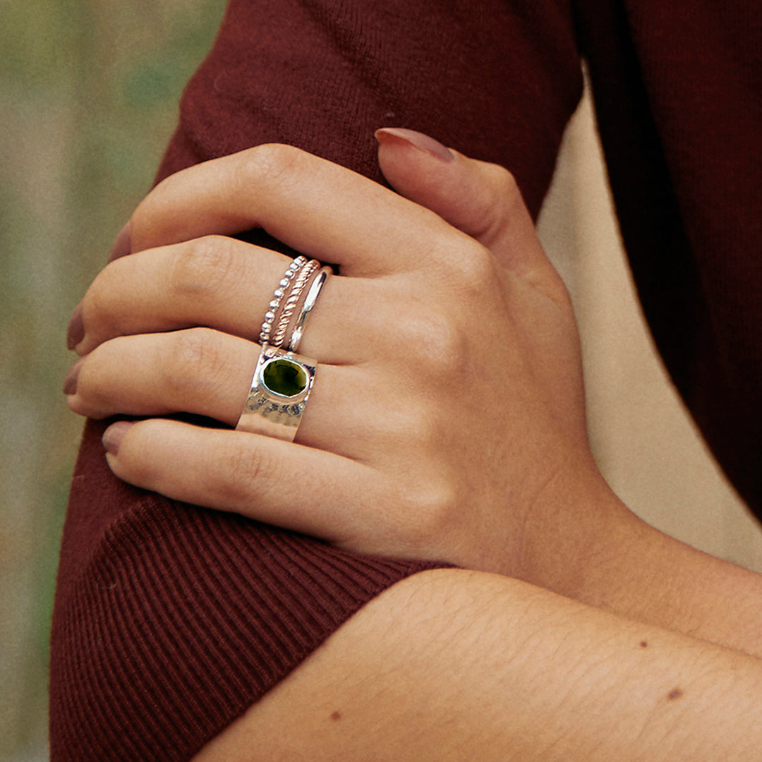 Close-up of woman wearing a sterling silver wide band ring with natural smoky quartz gemstone