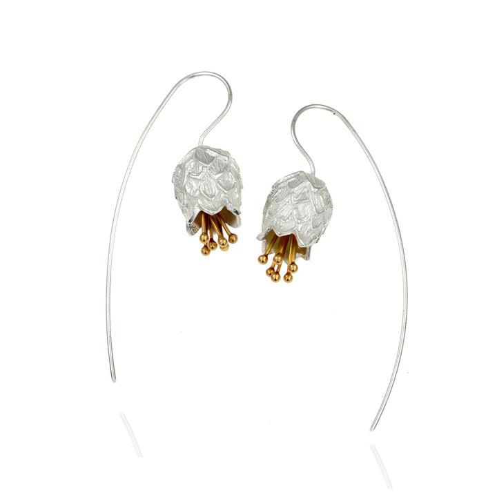 Silver and gold flower earrings on a white background