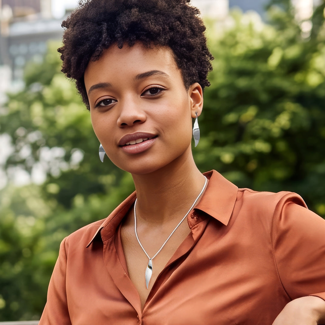 Woman wearing sterling silver earring and matching pendant from the Christin Ranger Silver Jewellery collection.
