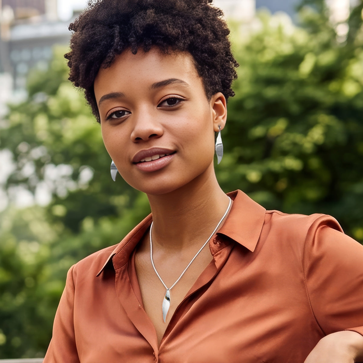 Woman wearing sterling silver earring and matching pendant from the Christin Ranger Silver Jewellery collection.