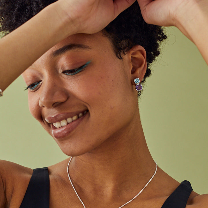 Model wearing sterling silver amethyst and blue topaz stud earrings