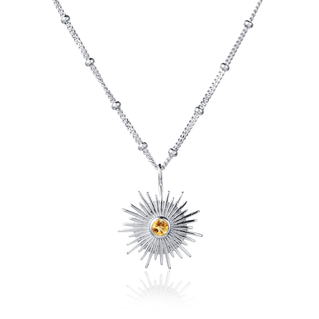 Silver sun necklace with beaded curb chain and set with a citrine gemstone on white background