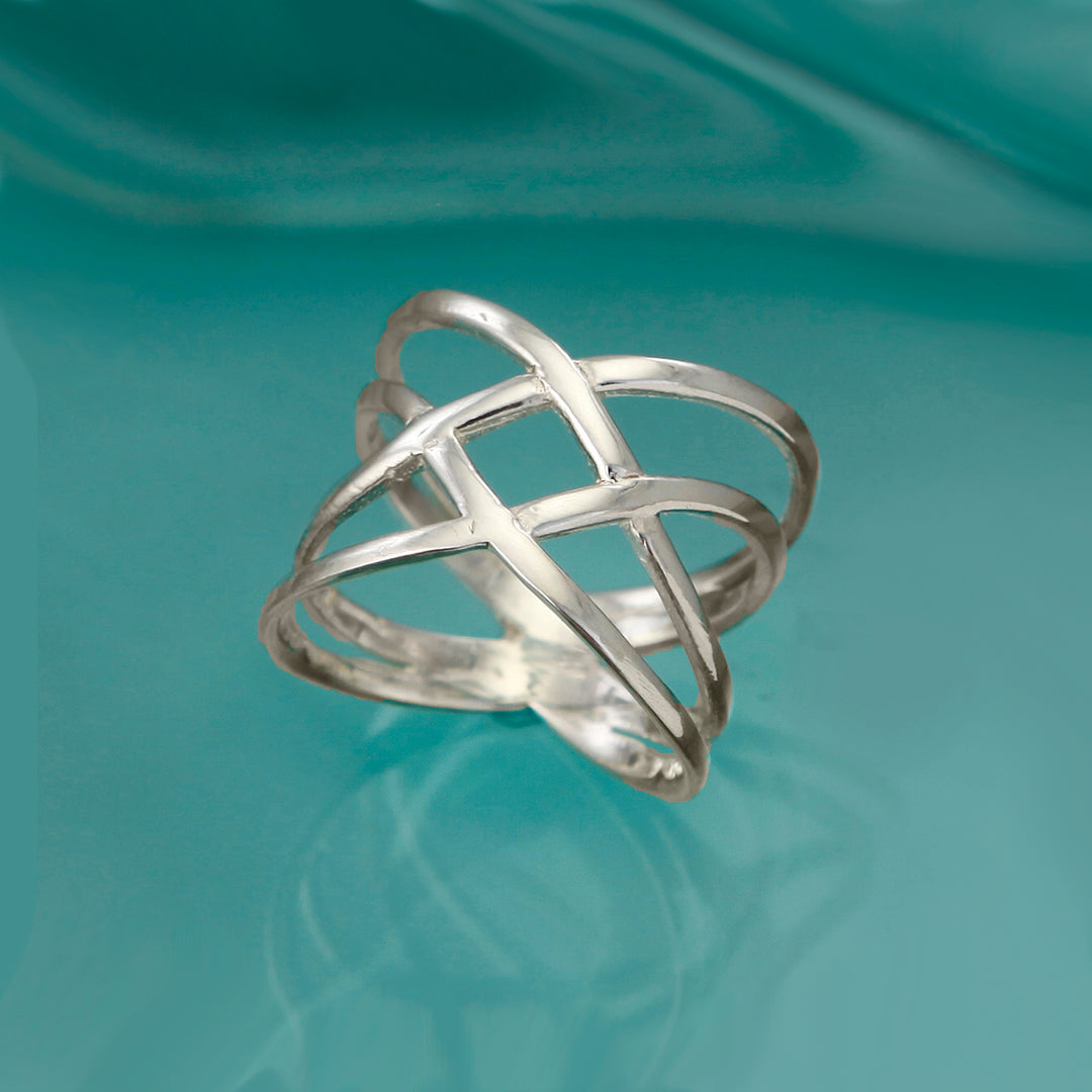 Sterling silver crossover wrap ring on an aqua background