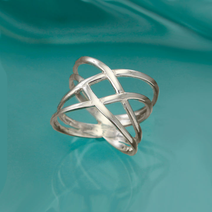Sterling silver crossover wrap ring on an aqua background