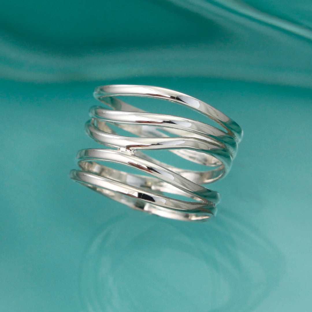 Alternative view of silver wide wrap ring on aqua background