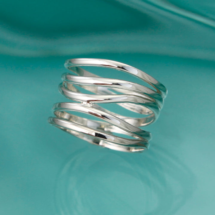 Alternative view of silver wide wrap ring on aqua background