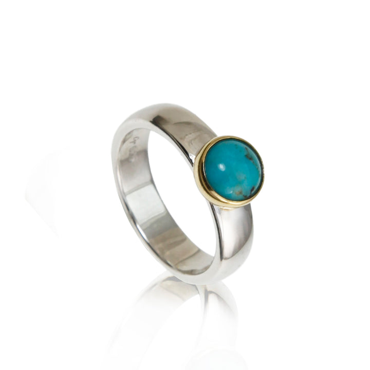 Silver and gold ring with a turquoise stone on a white background