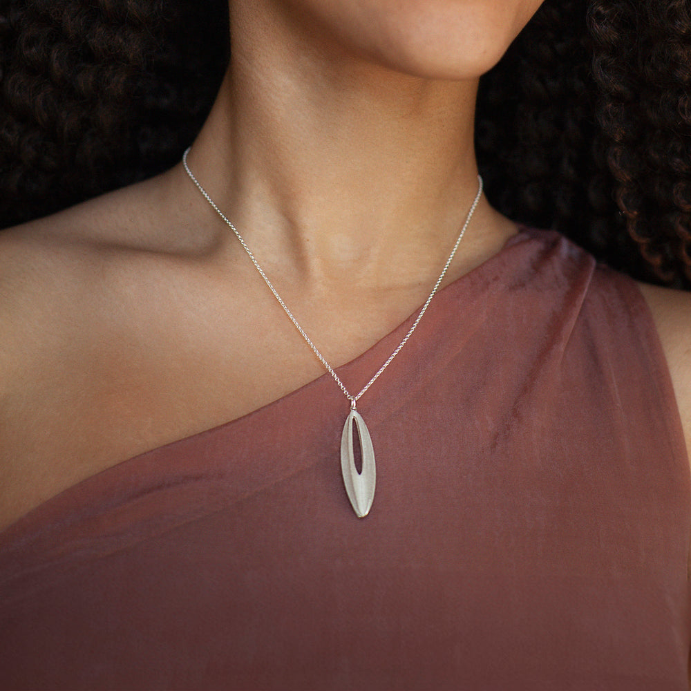 close-up of model wearing silver elliptical shaped necklace