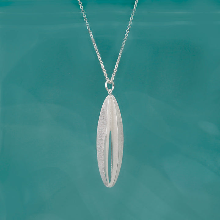 Silver elliptical shaped necklace on a teal background