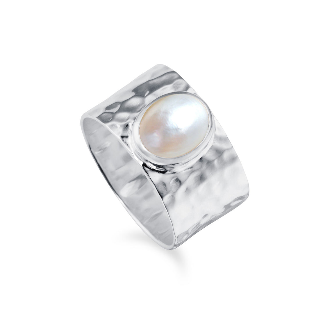 Wide textured silver ring with a mabe pearl on a white background