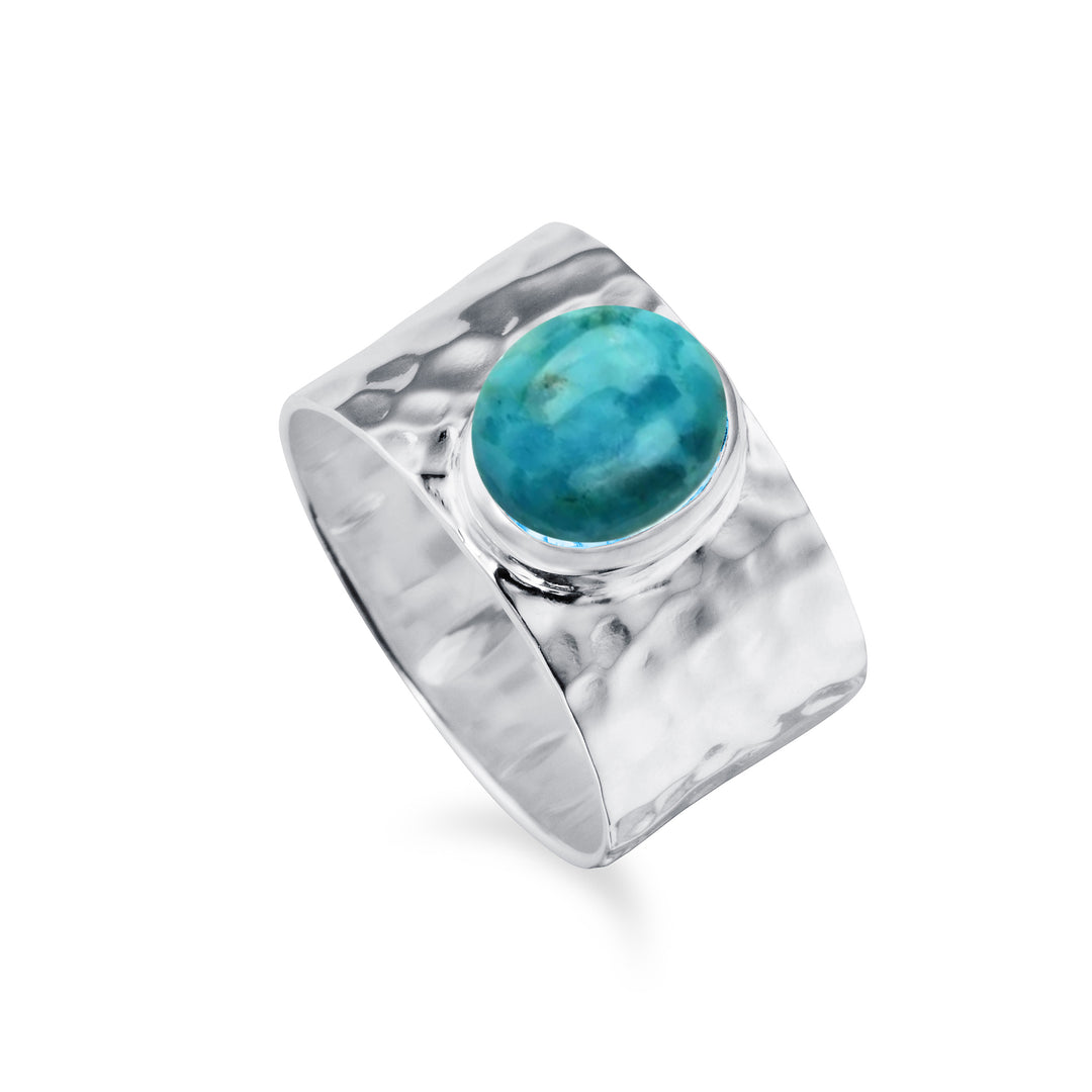 Wide silver hammered band ring with a natural turquoise stone against a white background