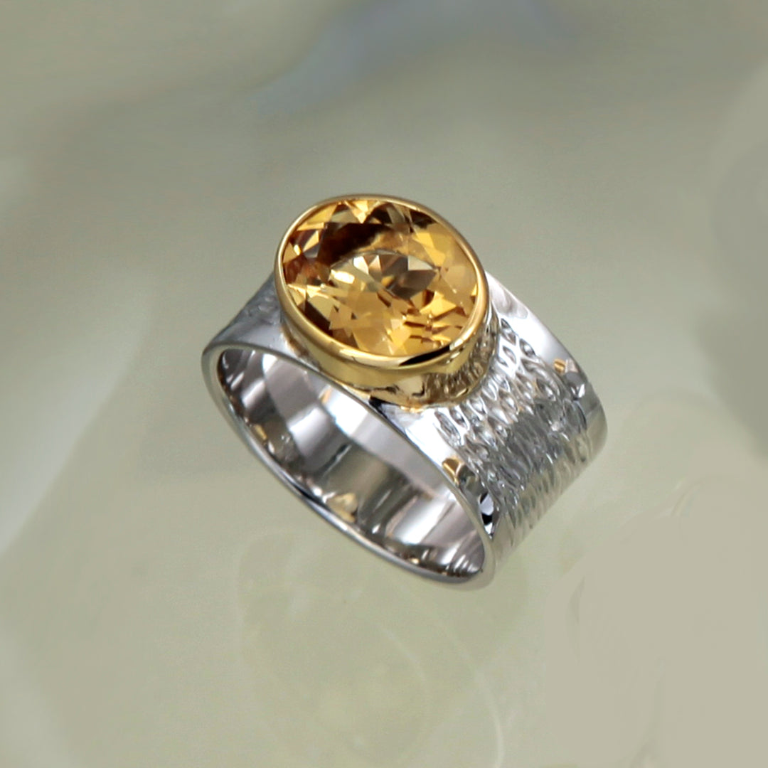 Large citrine ring in sterling silver and gold on a gray background