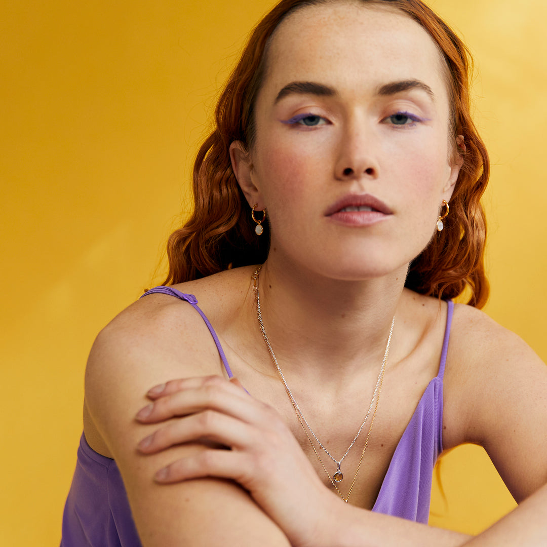 Model Shot of Gold and Amethyst Huggie Hoop Earrings