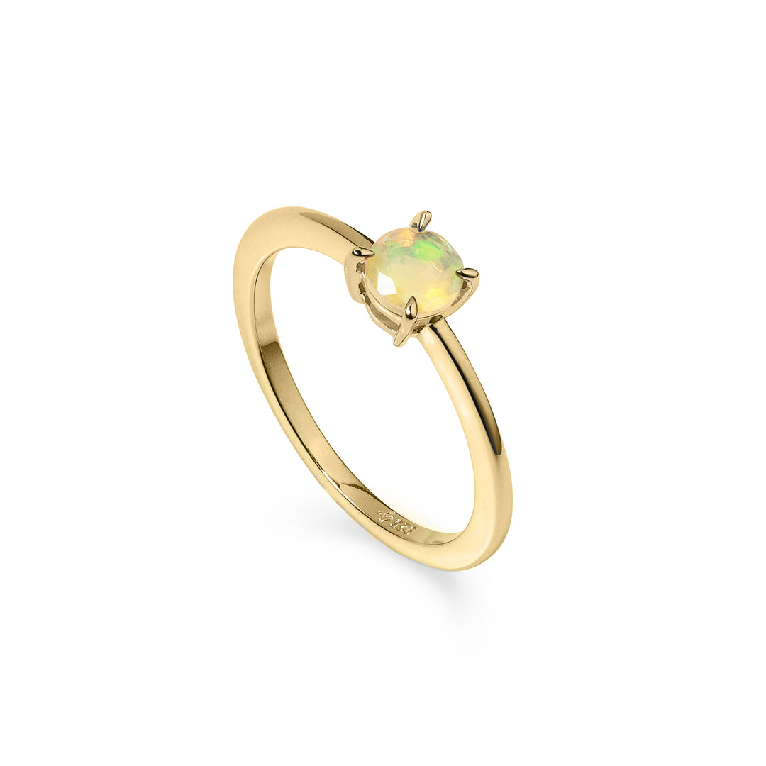 A gold solitaire ring with a round opal gemstone in the center, on a white background.