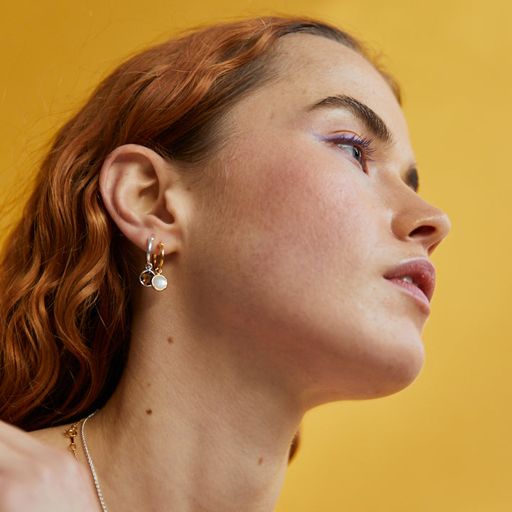 Model Shot of Gold and Amethyst Huggie Hoop Earrings